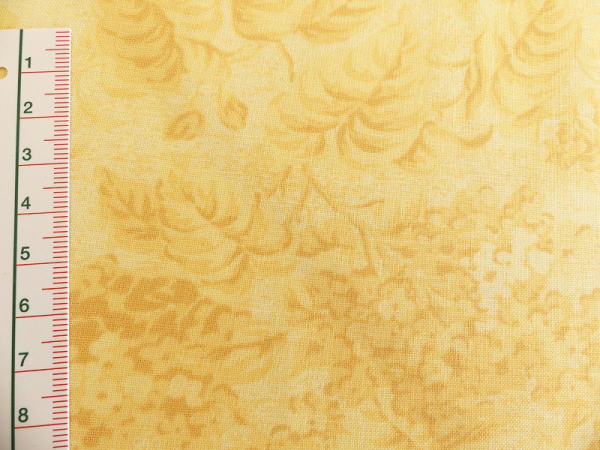 Stoff gelbes Blütenmuster auf einem etwas helleren Hintergrund. Detailansicht mit Maß.