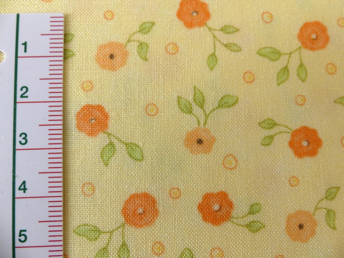 Patchworkstoff aus der Serie Refresh. Kleine orange Blüten auf gelbem Untergrund. Detailansicht mit Maß.