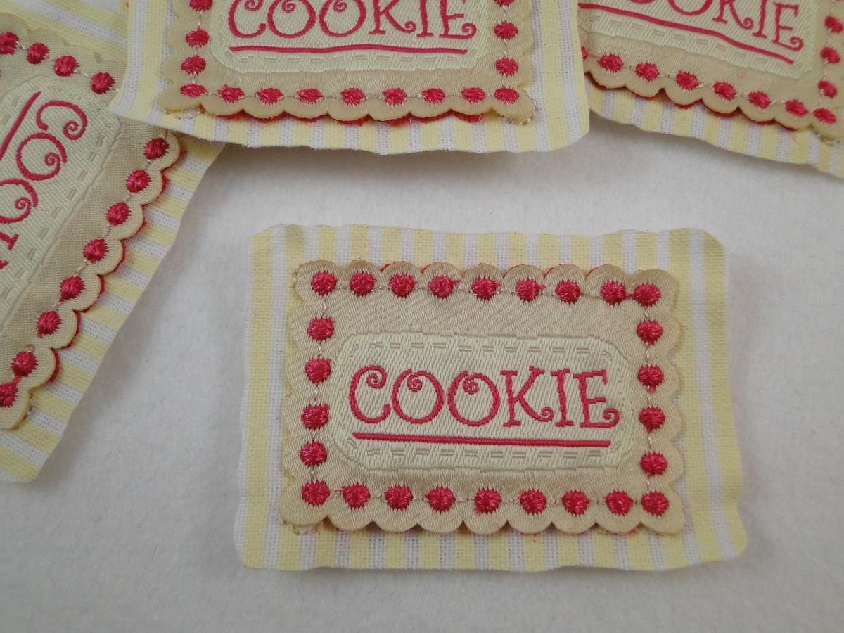 Etikett zum Aufnähen mit dem Wort Cookie in beige und pink. Mehrlagig.
