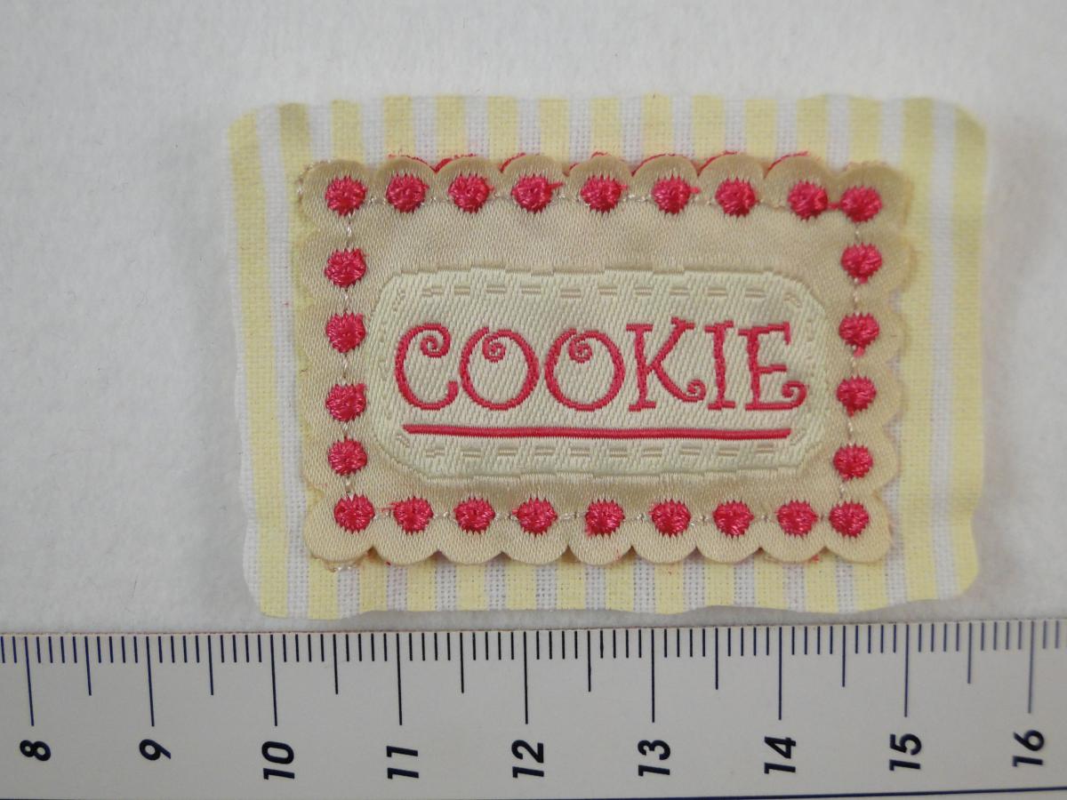 Etikett zum Aufnähen mit dem Wort Cookie in beige und pink. Detailansicht mit Maß.